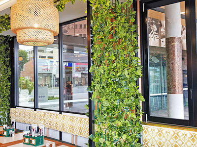 Cafe uses artificial green-vines for privacy screens & pergolas